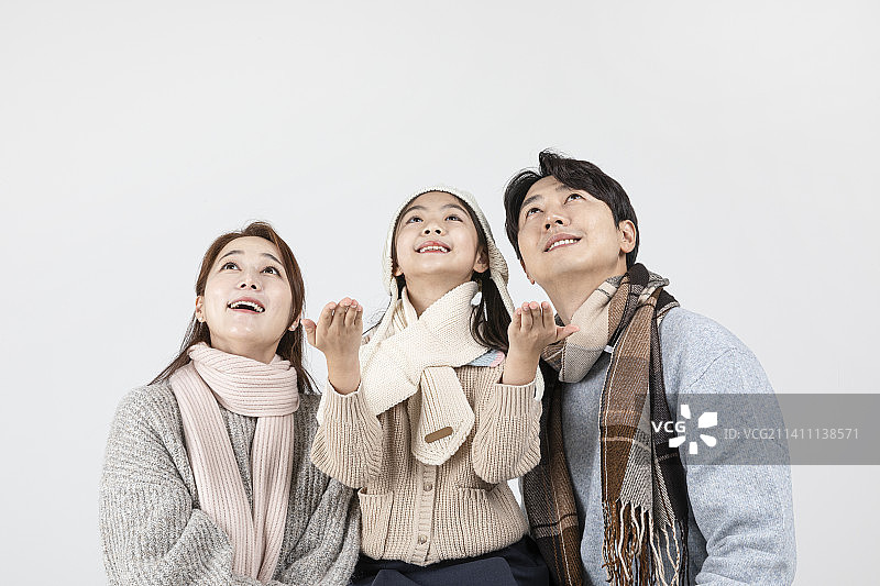 幸福的亚洲韩国家庭，隔离在白色背景下，穿着冬季时尚，戴着围巾图片素材