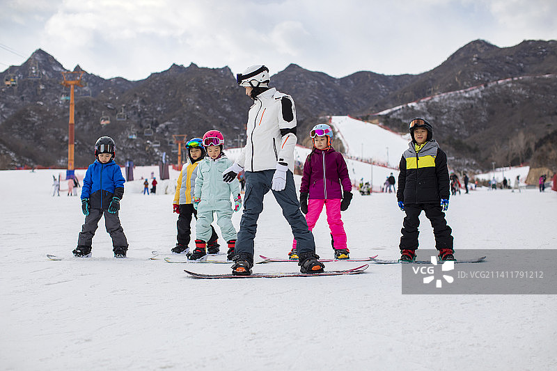 孩子们跟着教练在户外学滑雪图片素材