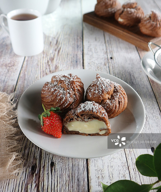 巧克力奶油泡芙放在白色盘子里，苏梅丹，印度尼西亚图片素材