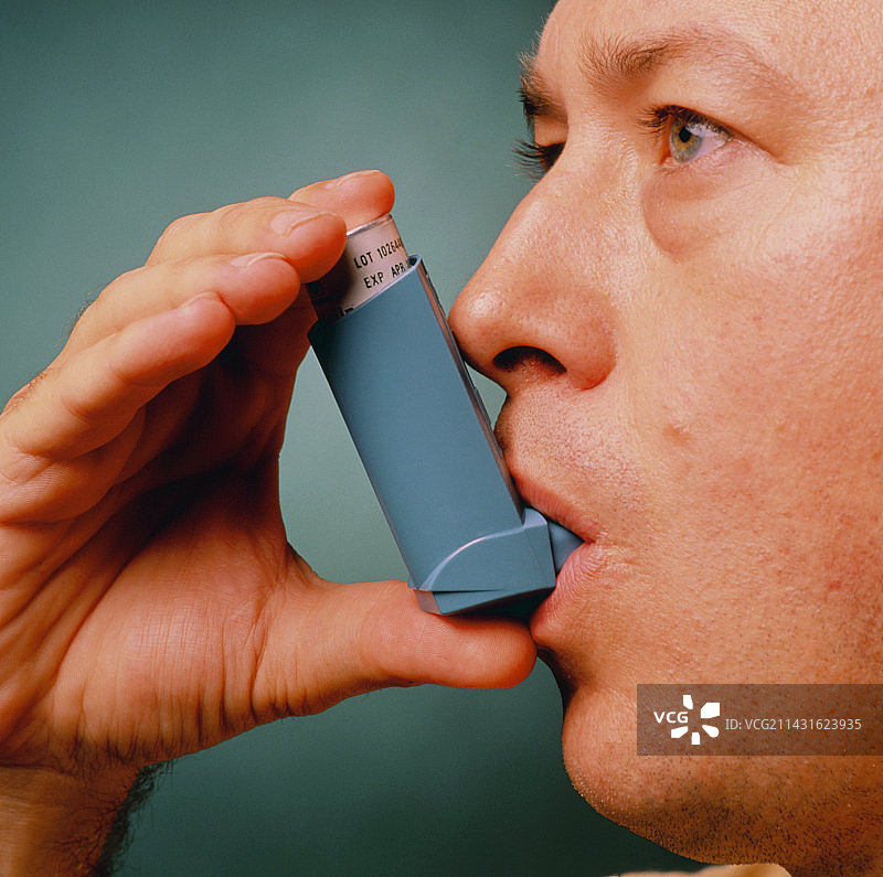 男子使用Ventolin吸入器控制哮喘图片素材