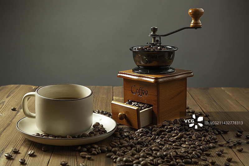 木头桌子上的咖啡豆，研磨机，咖啡杯图片素材