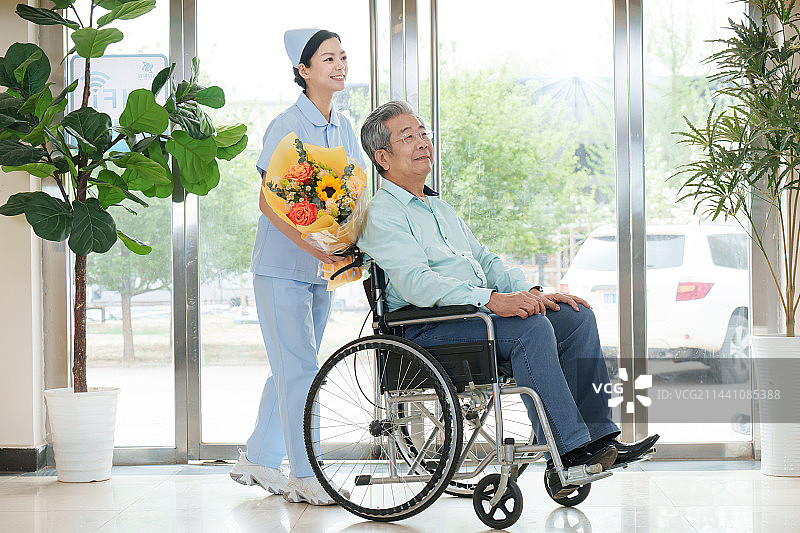 护士推着坐在轮椅上的老人图片素材