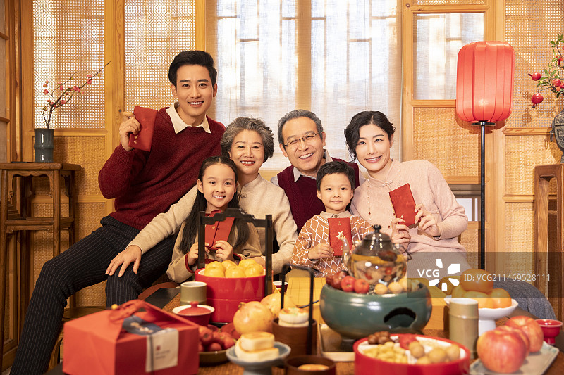 东方家庭过年：幸福一家人在客厅拜年、送红包图片素材