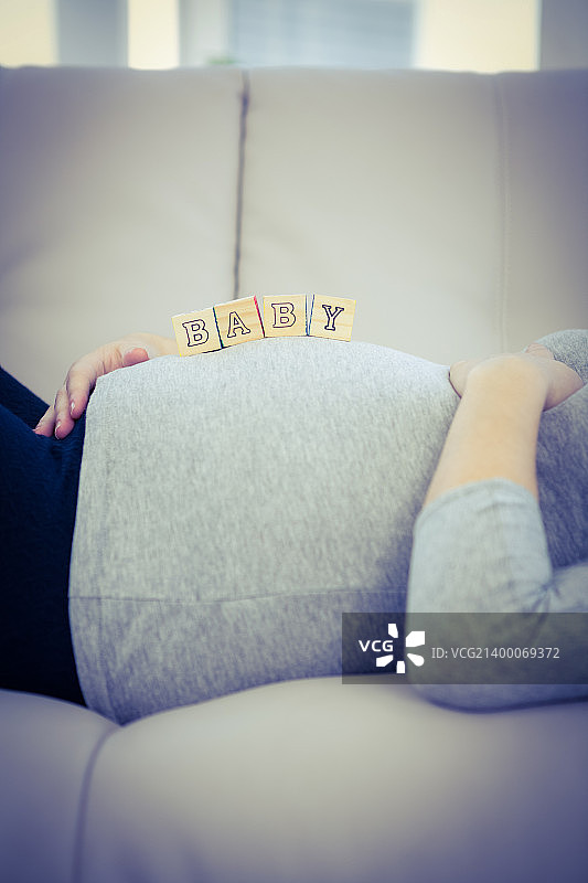 孕妇腹部用木块，躺在沙发上图片素材
