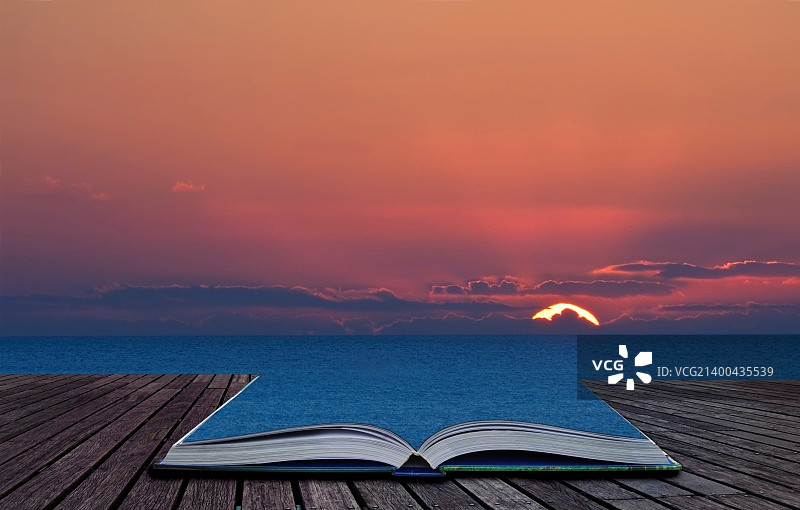 美丽的日落包含在书溢出和融合到风景背景图片素材