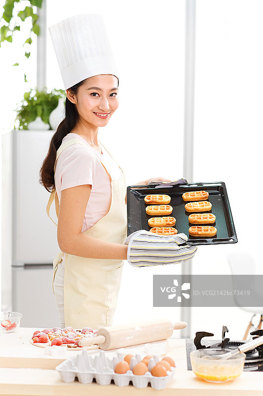 年轻女人在厨房烤面包图片素材
