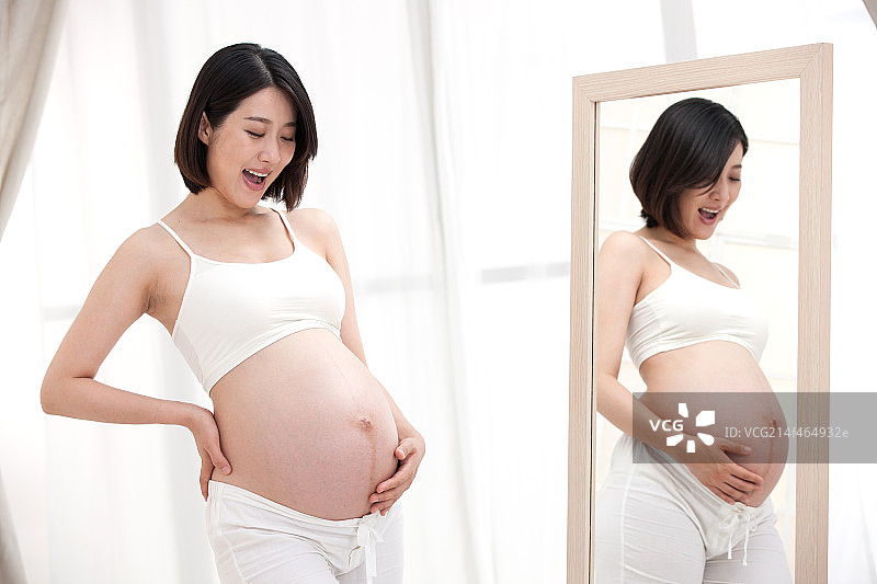 孕妇站在镜子前面图片素材