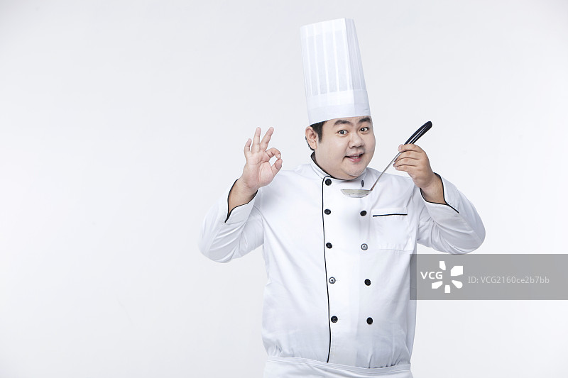 白色背景前拿汤勺的胖厨师图片素材