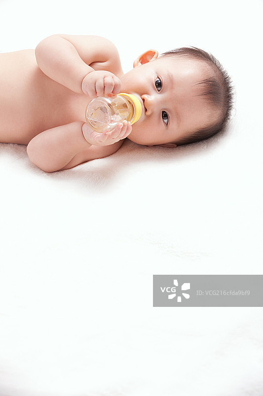 一个婴儿躺着喝奶图片素材