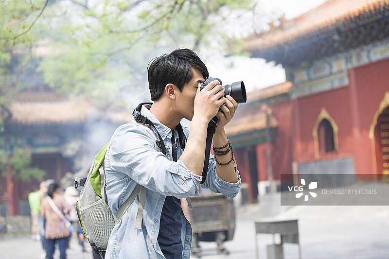 年轻男子在雍和宫拍照片图片素材