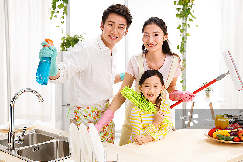 幸福的一家三口在厨房打扫卫生图片素材