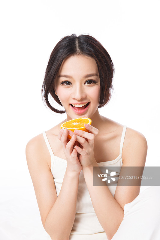漂亮的青年女人拿着橙子图片素材