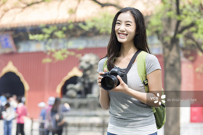 年轻女子拿着相机在雍和宫旅游图片素材