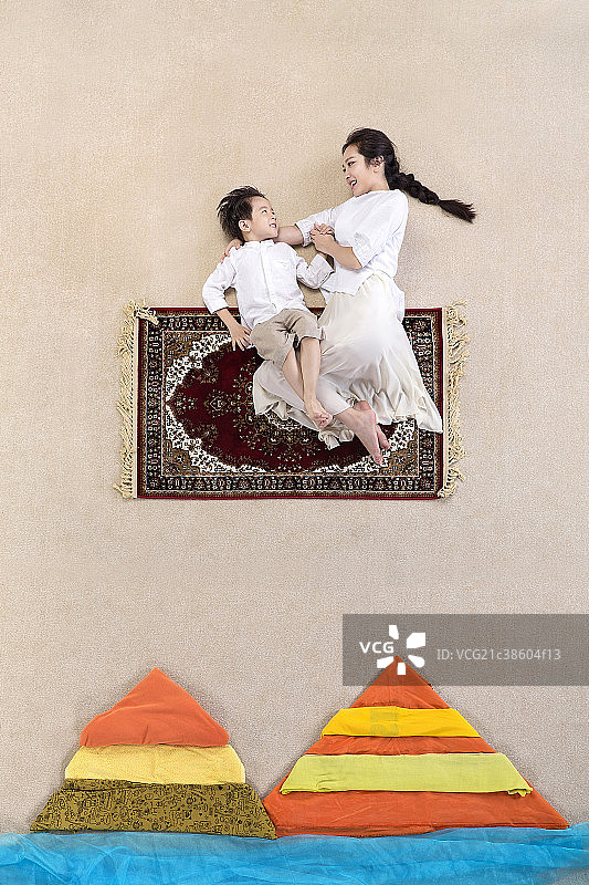 坐在飞毯上的母子二人图片素材