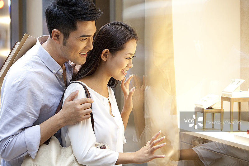 甜蜜情侣在香港观赏橱窗内的商品图片素材