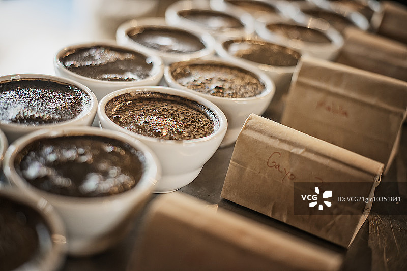 在咖啡加工棚里的取样程序，工作人员在小壶里煮咖啡并取样以测试混合咖啡的味道。图片素材