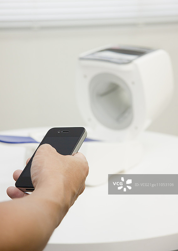 手持智能手机和自动血压计图片素材