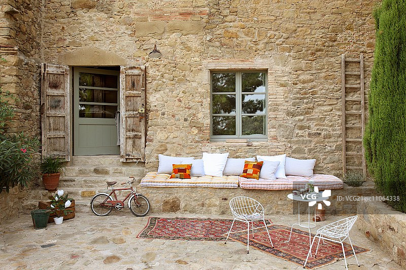 庭院精致的露台桌椅前的砖石长凳上的外墙意大利农舍图片素材