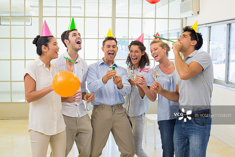 非正式的商务团队在办公室用香槟和派对庆祝图片素材