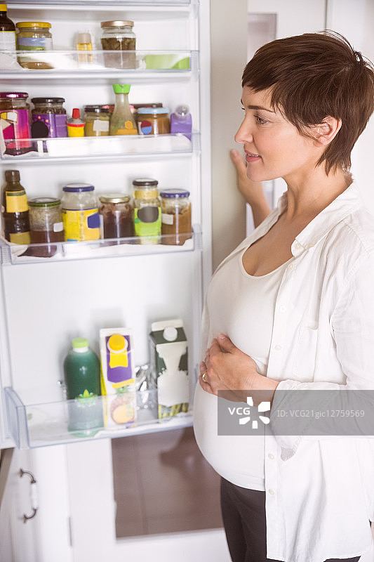 孕妇在厨房打开家里的冰箱图片素材