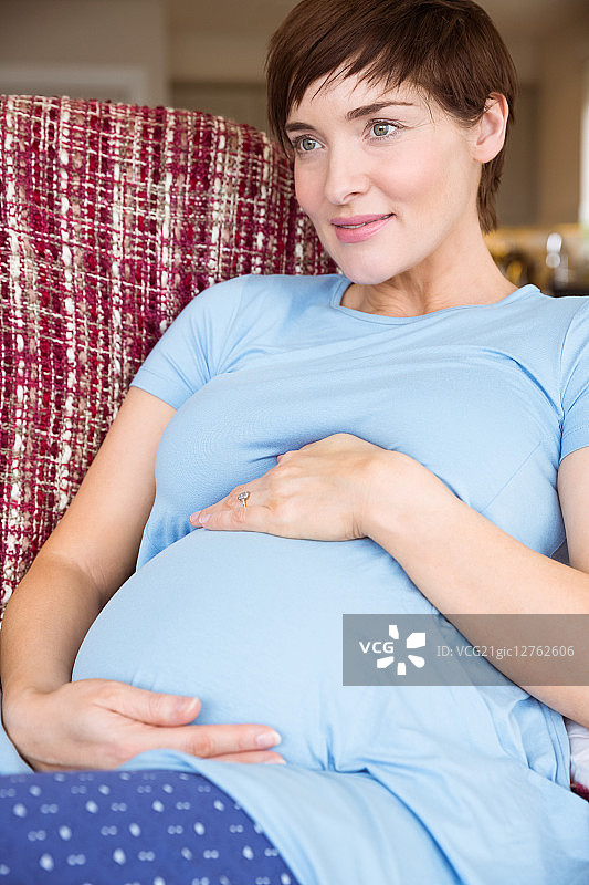 一名孕妇在起居室的沙发上休息图片素材