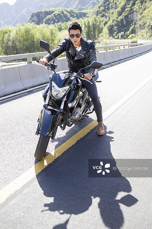 年轻男子骑摩托车兜风图片素材
