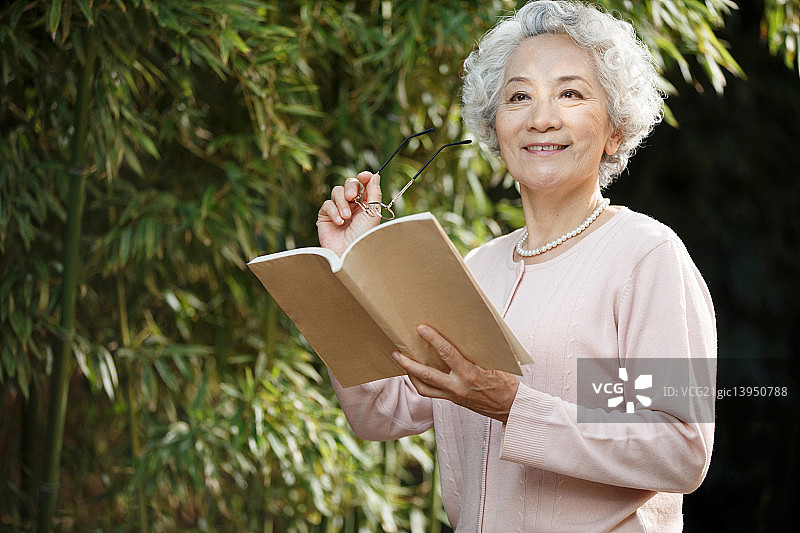 老年女人在院子里读书图片素材
