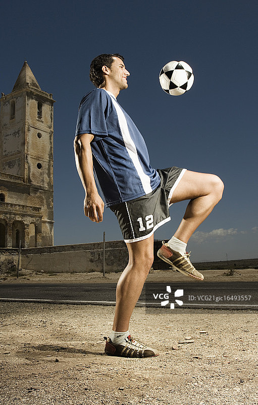 足球运动员用膝盖弹球图片素材
