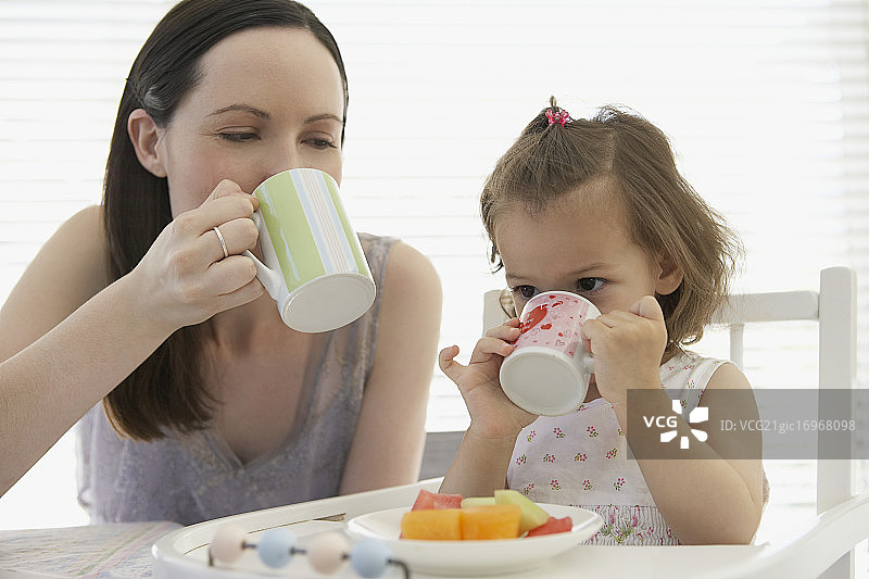 母亲和女儿用杯子喝水图片素材