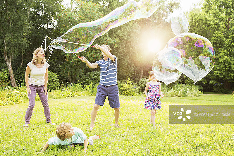 一家人在后院玩大泡泡图片素材