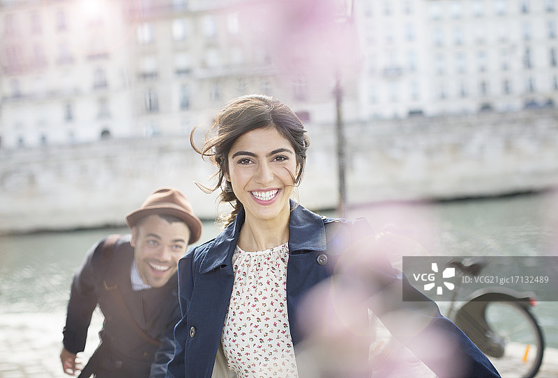 一对情侣在法国巴黎塞纳河边嬉笑奔跑图片素材