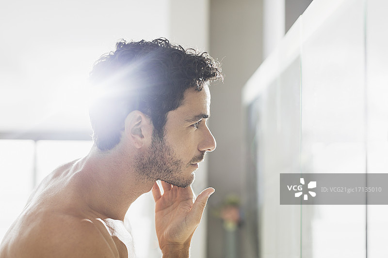 男人在浴室镜子里检查胡子图片素材