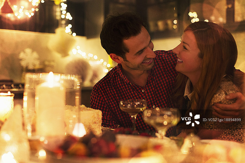 一对深情的情侣在烛光圣诞晚宴上拥抱图片素材
