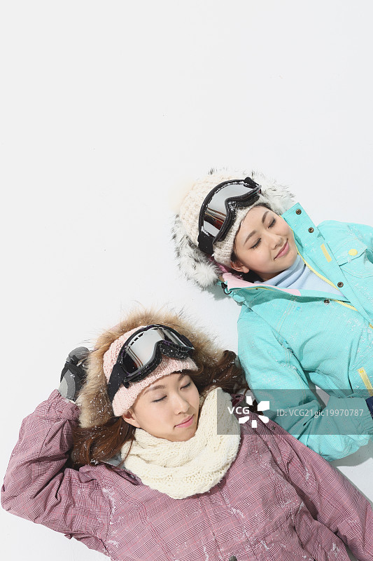 年轻的日本女性穿着白色背景的滑雪板图片素材