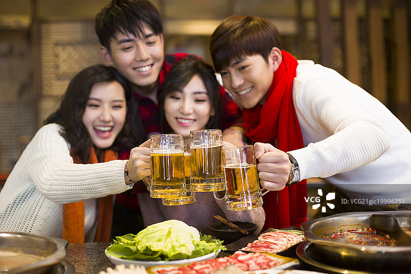 年轻朋友们在火锅店吃饭喝啤酒图片素材