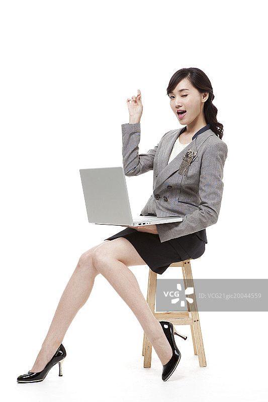 女商人坐在椅子上用笔记本电脑做手势图片素材