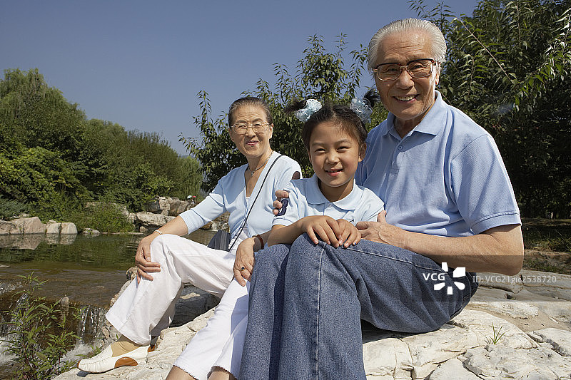 爷爷奶奶和孙女坐在石头上图片素材
