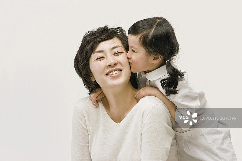 女儿亲吻母亲的脸颊图片素材