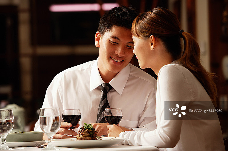 一对情侣在餐厅，肩并肩坐着图片素材