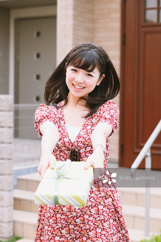 一个日本女孩微笑着拿着礼物图片素材