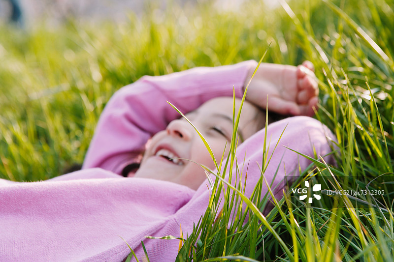 年轻的女孩在草原上微笑图片素材