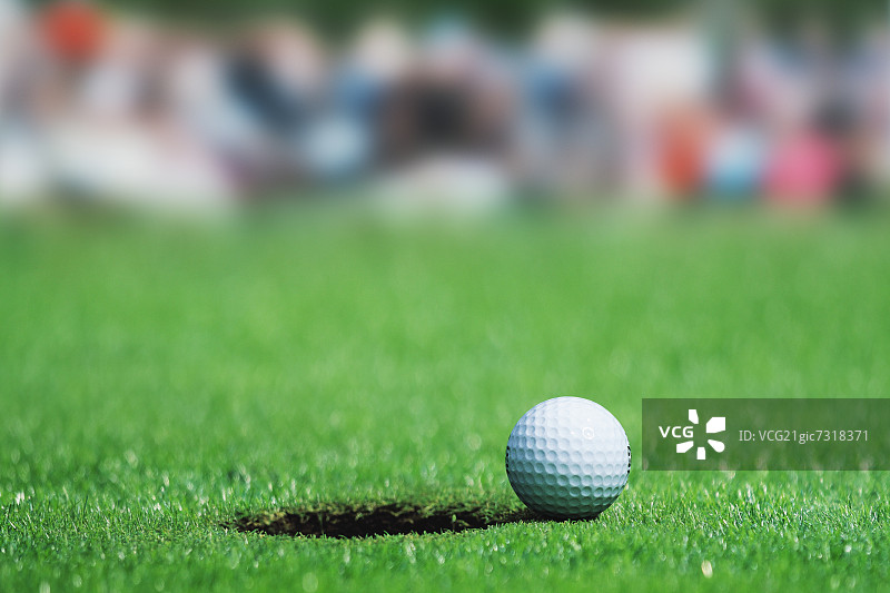 高尔夫球在绿色旁边的洞图片素材