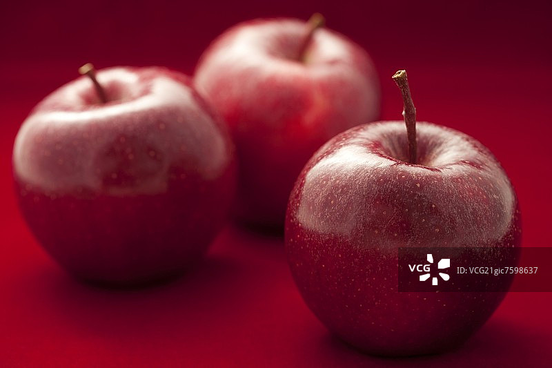 红色背景下的红苹果图片素材