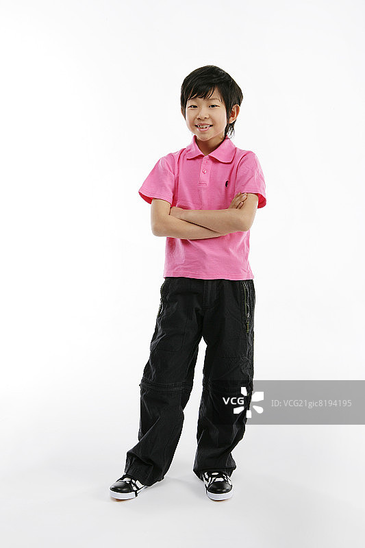 男孩(12-13岁)双臂交叉站着，面带微笑，像极了图片素材