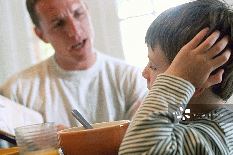 父亲和儿子在厨房吃早餐图片素材