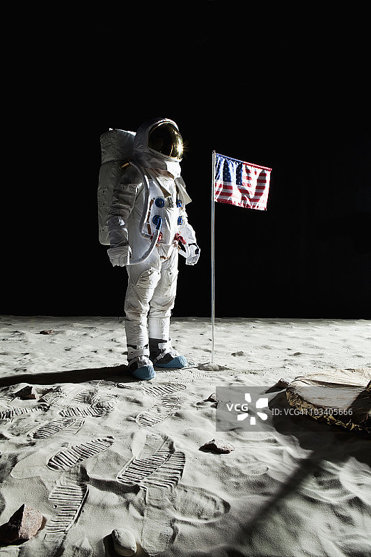 一个在月球上站在美国国旗旁边的宇航员图片素材