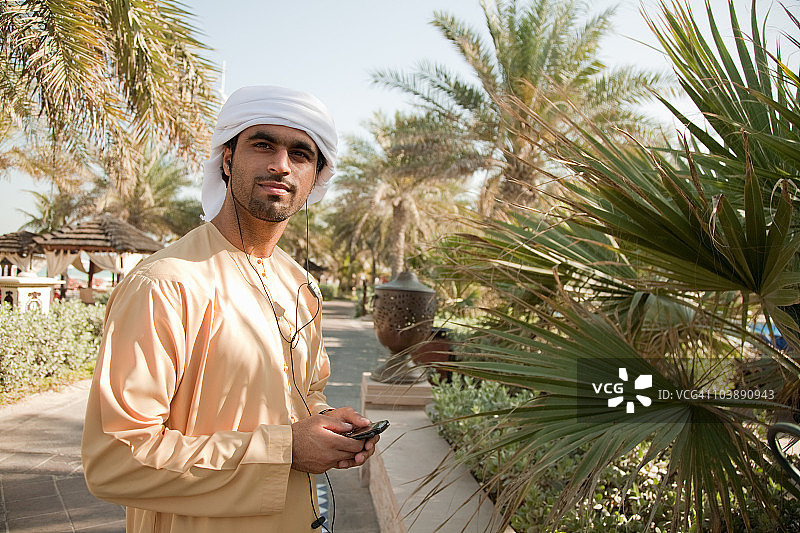 一个中东人在用手机听音乐图片素材