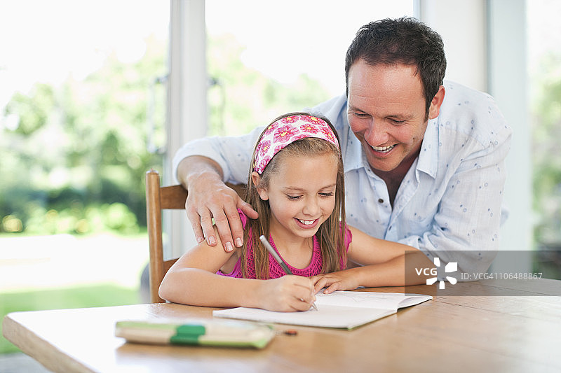 父亲指导女儿(8-9)完成家庭作业图片素材