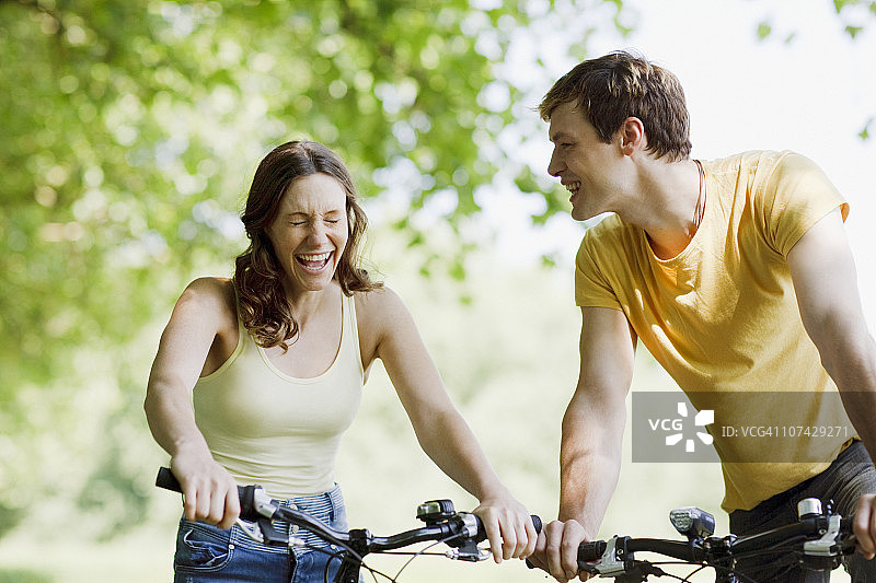 一对在自行车上大笑的夫妇图片素材