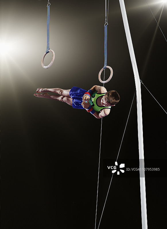年轻男子体操运动员从吊环上下来图片素材